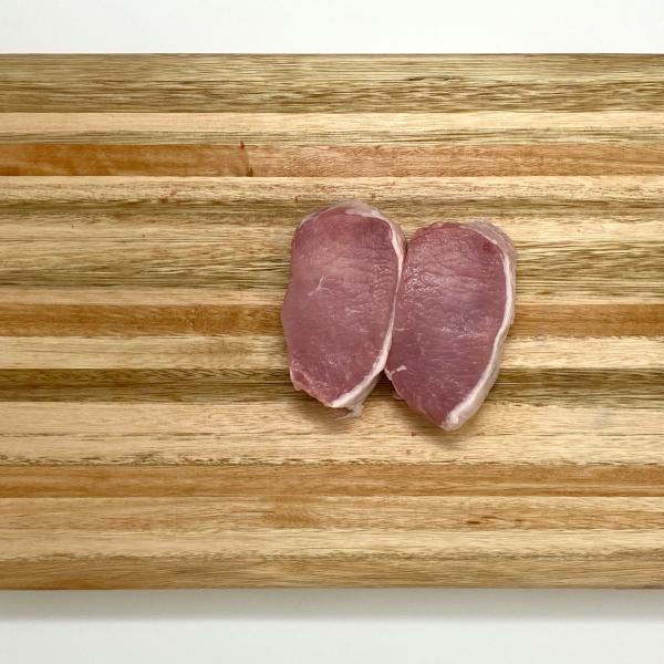 two pork chops on cutting board